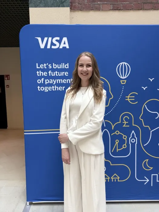Johanna Valkonen standing in front of a Visa backdrop reading "Let's build the future of payments together".